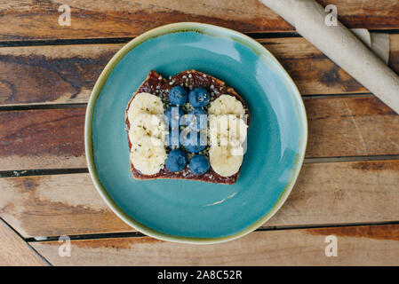 toast with chocolate paste, bananas and blueberries on the blue plate Stock Photo