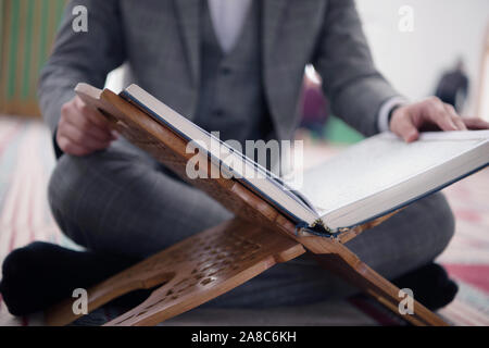 Religious young hafiz muslim man praying inside the mosque and reading holy book of qoran or koran. Stock Photo