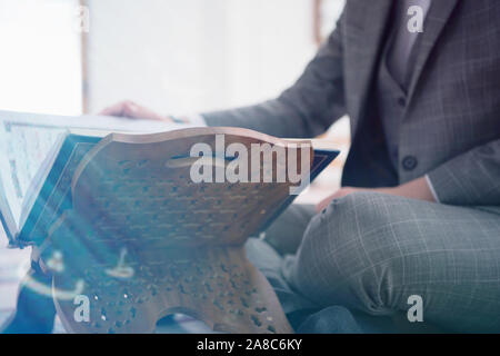 Religious young hafiz muslim man praying inside the mosque and reading holy book of qoran or koran. Stock Photo