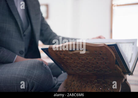 Religious young hafiz muslim man praying inside the mosque and reading holy book of qoran or koran. Stock Photo