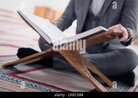 Religious young hafiz muslim man praying inside the mosque and reading holy book of qoran or koran. Stock Photo