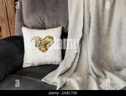 Christmas decoration decorative pillow made of multi color gold and white shimmer sequin reversible fabric on home living room couch. Christmas decora Stock Photo