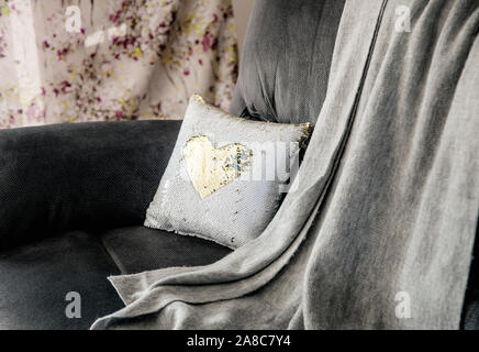 Christmas decoration decorative pillow made of multi color gold and white shimmer sequin reversible fabric on home living room couch. Christmas decora Stock Photo