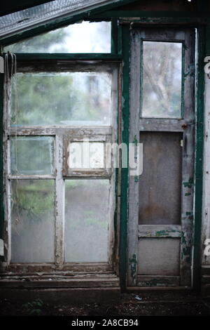 Old window frame with peeling paint and dirty glass. Abandoned b Stock Photo