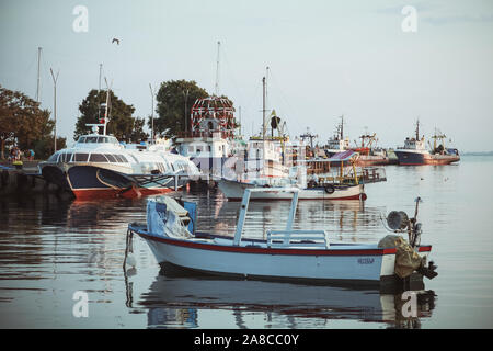 Nesebar, Bulgaria - July 20, 2014: Nesebar port view with moored ships and motorboats. Ordinary people walk the embankment Stock Photo