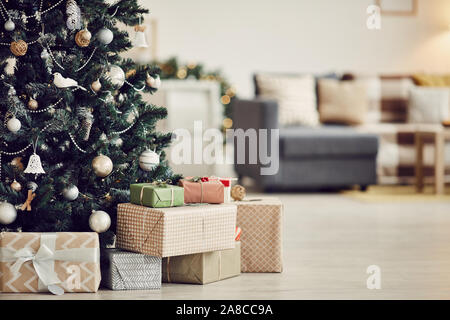 Image of decorated Christmas tree with gift boxes under it on the floor in the living room Stock Photo