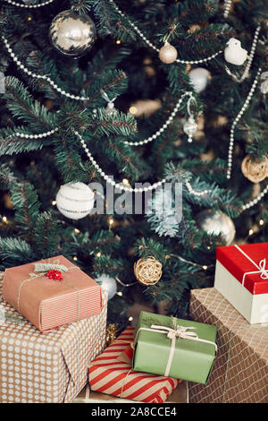 Close-up of wrapped Christmas presents lying under the decorated Christmas tree Stock Photo