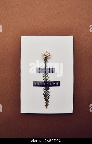 Close-up of handmade greeting card decorated with flower made for Christmas isolated on brown background Stock Photo