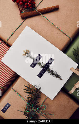 Close-up of white decorated greeting card lying on wrapped Christmas present prepared for Christmas holidays Stock Photo