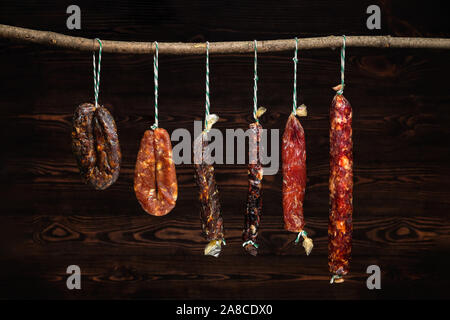 Variety of dried sausage on twine hanging in country wooden barn Stock Photo