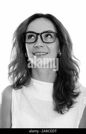 Face of young happy woman smiling while thinking and looking up Stock Photo