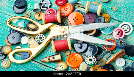 Sewing tools, scissors, buttons and threads on wooden table Stock Photo