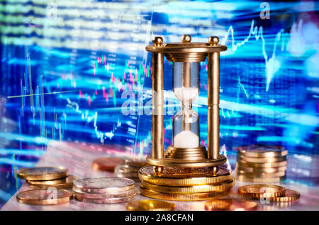 Computer trading on international financial markets with an hourglass in the foreground Stock Photo