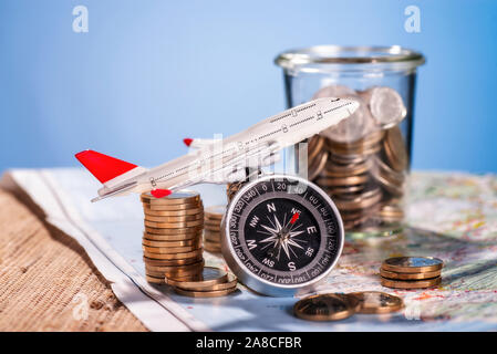 Airplane with compass and coins on a map Stock Photo