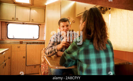 Passenger view of couple talking inside of their retro camper van. Autumn camping Stock Photo