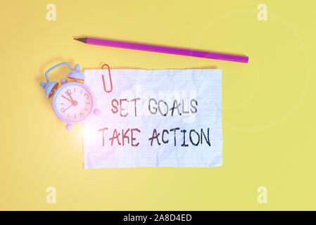 Conceptual hand writing showing Set Goals Take Action. Concept meaning Act on a specific and clearly laid out plans Metal alarm clock ccrushed sheet p Stock Photo
