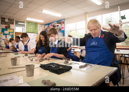 Prime Minister Boris Johnson tries his hand at making an Antony Gormley inspired clay figure during an arts class whilst visiting the George Spencer Academy in Nottingham, while on the General Election campaign trail around the country. Stock Photo