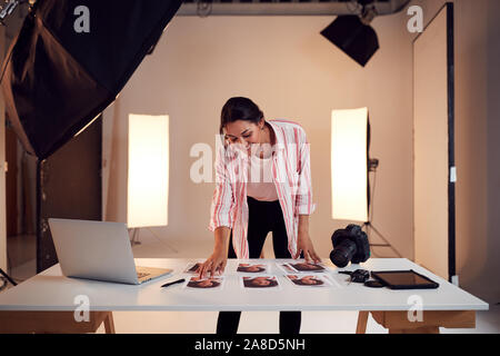 Female Photographer Editing Images From Photo Shoot In Studio Stock Photo