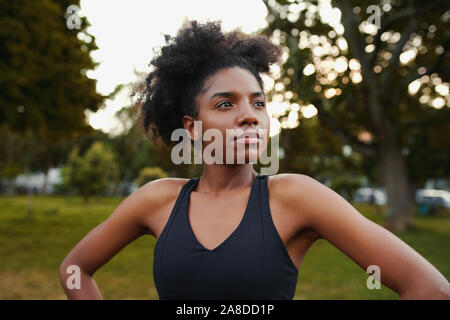Portrait of confident african american sporty fit young woman looking away in the park Stock Photo