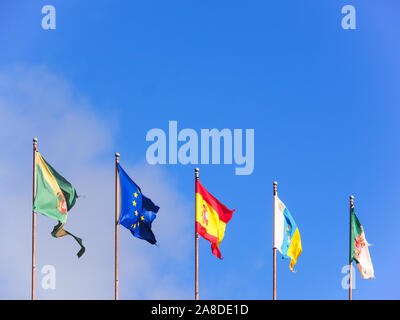 Five flags of different countries isolated on blue sky Stock Photo