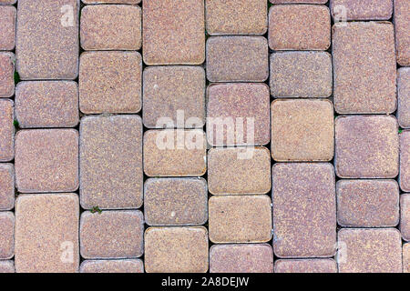 Light brown stone pavement in full frame with square and rectangular bricks of different sizes, viewed from above Stock Photo