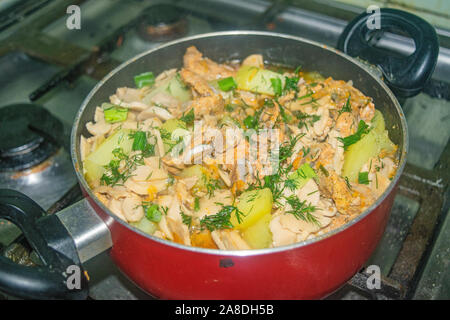 Meat with onions, carrots, potatoes, dill and Bay leaf is stewed in a saucepan. Home cooking Stock Photo