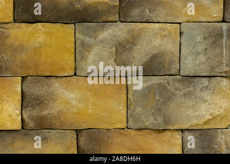 Texture, wall made of yellow brown decorative stone of rectangular shape, building material large brick for decorating the outer wall, textured backdr Stock Photo