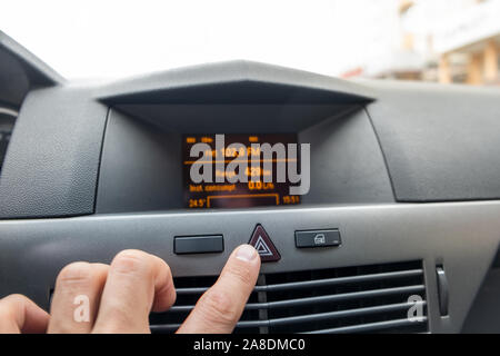 Red triangle emergency button in a car interior. Stock Photo