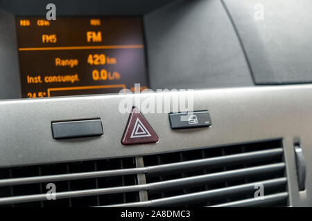 Red triangle emergency button in a car interior. Stock Photo
