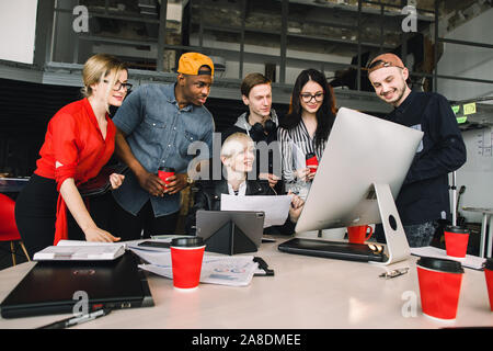 Group of young six business people and software developers in casual outfit working as a team in loft office Stock Photo