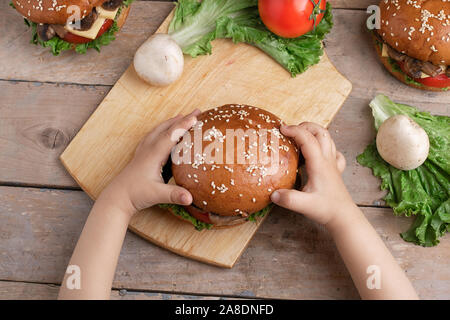 girl holding mushroom burger, top view and close up Stock Photo