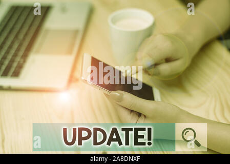 Conceptual hand writing showing UPDATE. Concept meaning make something more modern or up to date like software program woman with laptop smartphone an Stock Photo