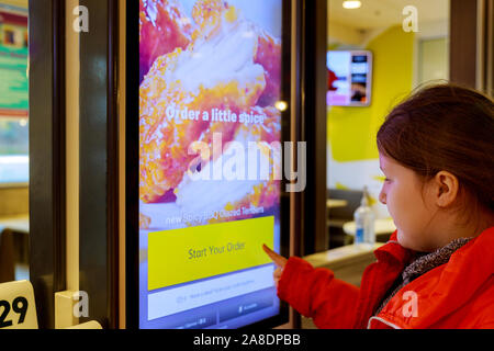 NewYork NY NOV 07 2019: Customers at a McDonald's orders and pay through self ordering kiosks. McDonald's American fast food company. Stock Photo