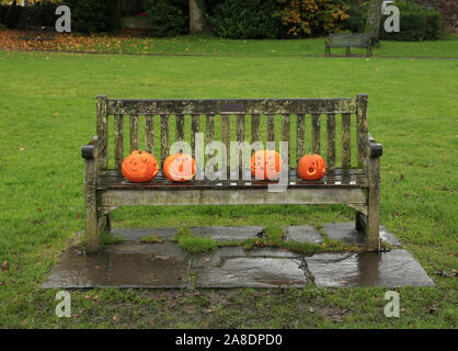 Carved Halloween pumpkins left on a bench in Grasmere village, Cumbria, UK. Stock Photo
