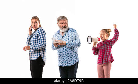 Family members arguing with one another on white studio background. Concept of human emotions, expression, conflict of generations. Woman, man and little girl. Problem of parents and childrens. Stock Photo