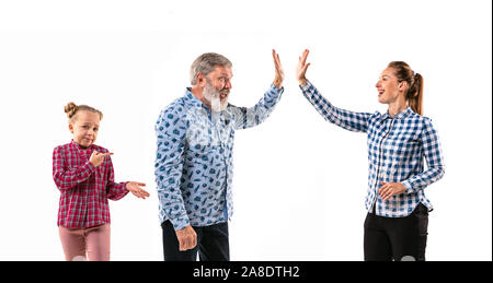 Family members arguing with one another on white studio background. Concept of human emotions, expression, conflict of generations. Woman, man and little girl. Too busy parents. Stock Photo