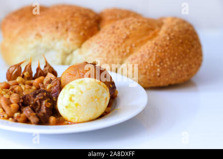 Hot plate for the Sabbath, a pot of spicy meat cooked with potatoes,  barleys, wheat and eggs. Pot of cholent Hamin in hebrew, challah-special  bread in Jewish cuisine. Traditional food Jewish Shabbat Stock Photo - Alamy