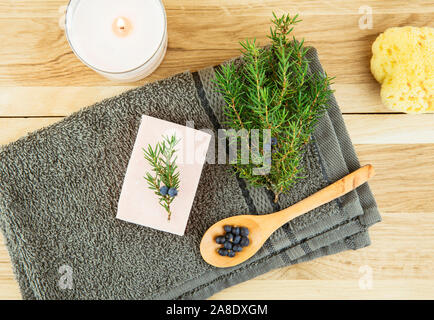 Flat lay view Juniper latin Juniperus communis berry soap bar, juniper tree branch with confier cones and spoon with berries, copy space.  Juniper tre Stock Photo
