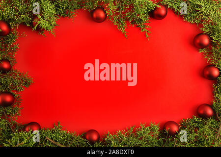 Flat lay red Christmas copy space with pine branches and red Christmas baubles all around Stock Photo