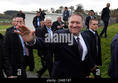 07 November 2019, Bavaria, Mödlareuth: Mike Pompeo, (M) US Secretary of State, visits Mödlareuth at Hof and waves as he walks past the remains of a wall. The inner-German border once ran through the village with just under 50 inhabitants, which in Mödlareuth was partly secured by a wall. The village had therefore been given the nickname 'Little Berlin'. Photo: John Macdougall/AFP-Pool/dpa Stock Photo