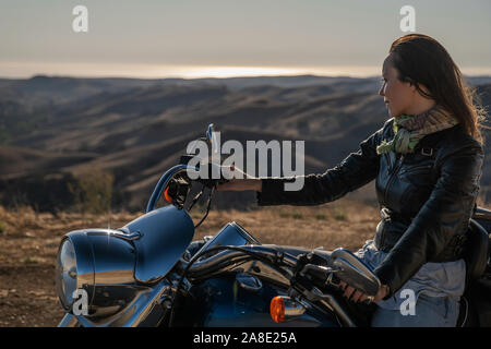 Woman biker sitting on her motorcycle. Stock Photo