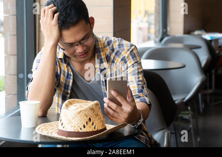 young business farmers sitting in a restaurant and watching smartphones to learning information in agriculture. Concept of modern agriculture. Stock Photo