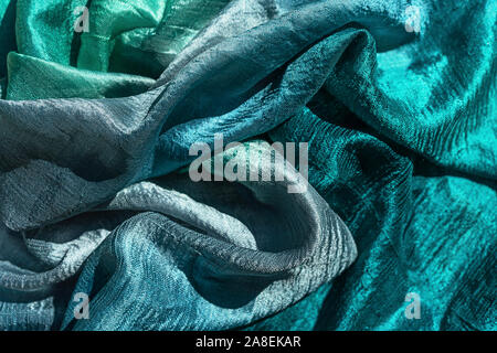 Photo of silk cloth in trendy green mint blue color as texture holiday background. Flat lay, top view. Stock Photo