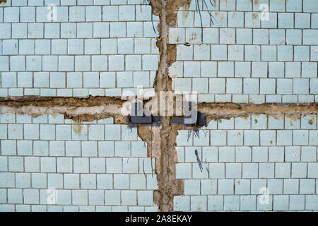 Blue tiles on a wall as a background image. Blue old tile with seams between concrete slabs. Stock Photo