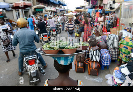 TOGO, Lome, Grande Marche, Grand market, woman carry vegetable okra on the head for selling Stock Photo