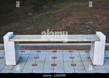 Wooden bench with marble legs in a public Park. Stock Photo