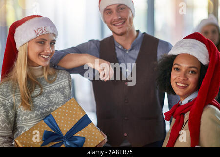 Happy business friends in santa hat at Xmas business party. Stock Photo