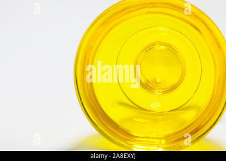 an egg cup in yellow glass lying on the side against white background Stock Photo