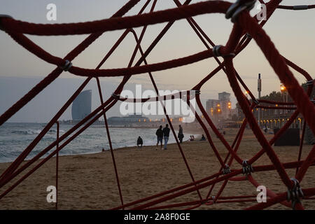 A view of Barcelona city beach through the geometric shapes of a rope climber Stock Photo