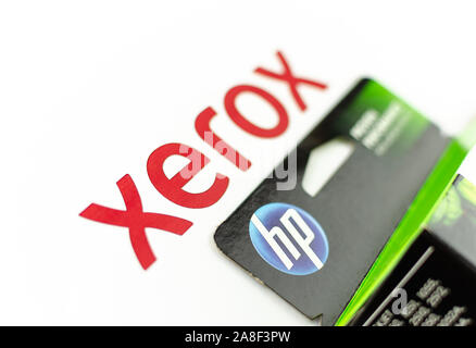 XEROX and HP logos seen on paper and printer cartridge ink. Concept photo - XEROX is a paper, HP is an ink. Selective focus. Stock Photo